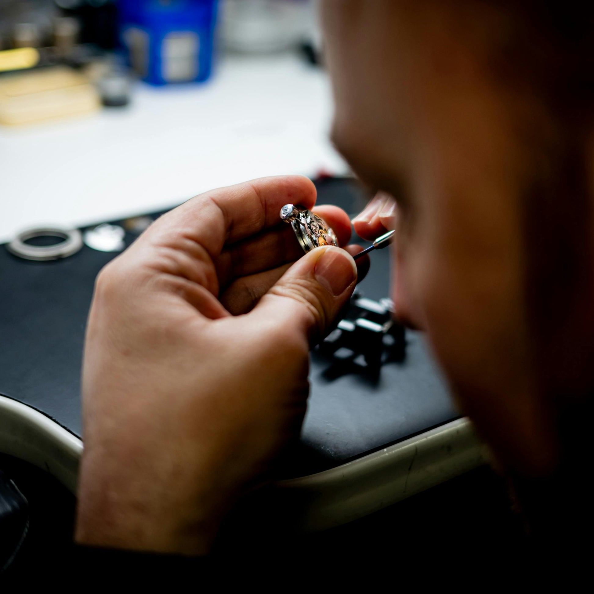 Person examining a ring with a close-up of their hands on a desk.